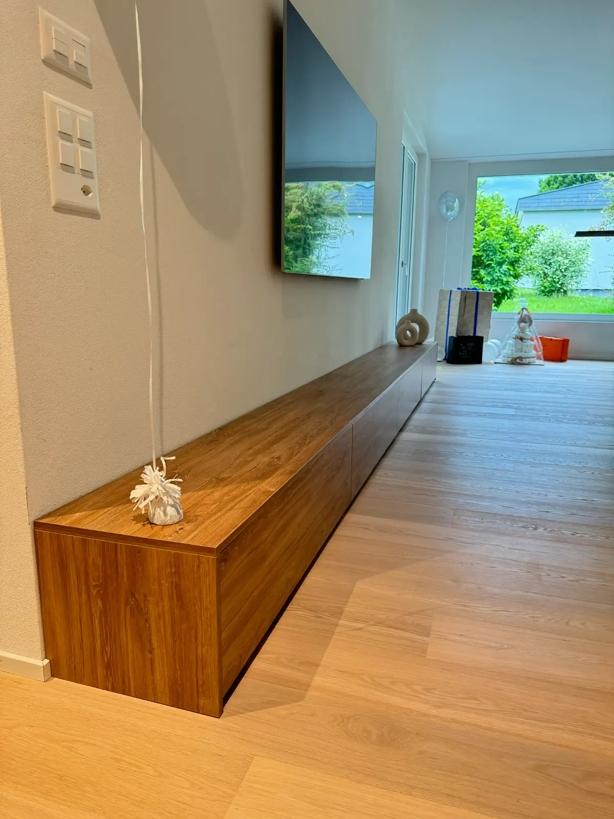 Lange TV Kommode aus Holz mit durchgehender Front und integriertem Stauraum im modernen Wohnbereich