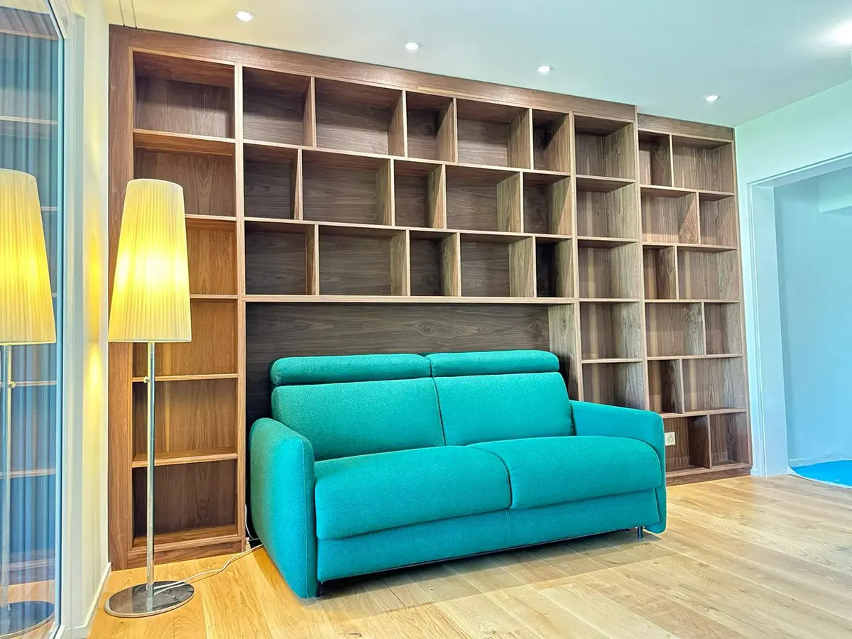 Moderne Wohnwand mit großem Einbauregal aus dunklem Holz und integriertem Sofa im Wohnbereich